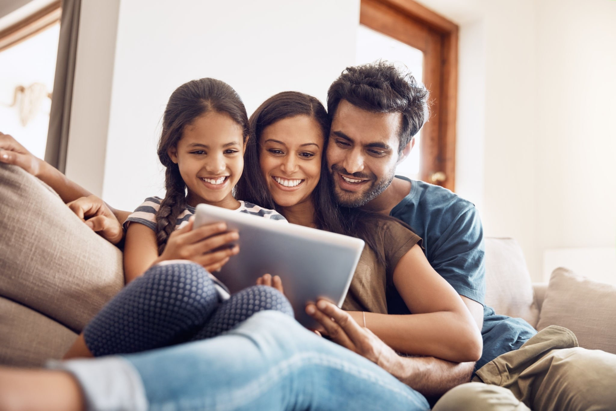 family share smiles whilst using a tablet